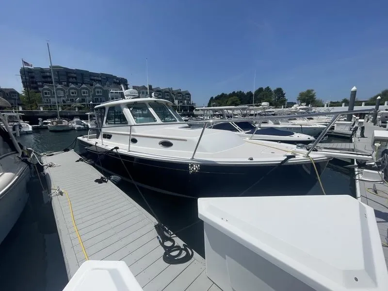 Slide: The Image of 2006 Back Cove 29 boat docked at marina under clear blue sky. - 6