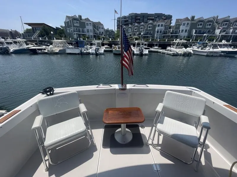 Slide: The Image of 2006 Back Cove 29 boat deck with chairs, table, and American flag in marina setting. - 8