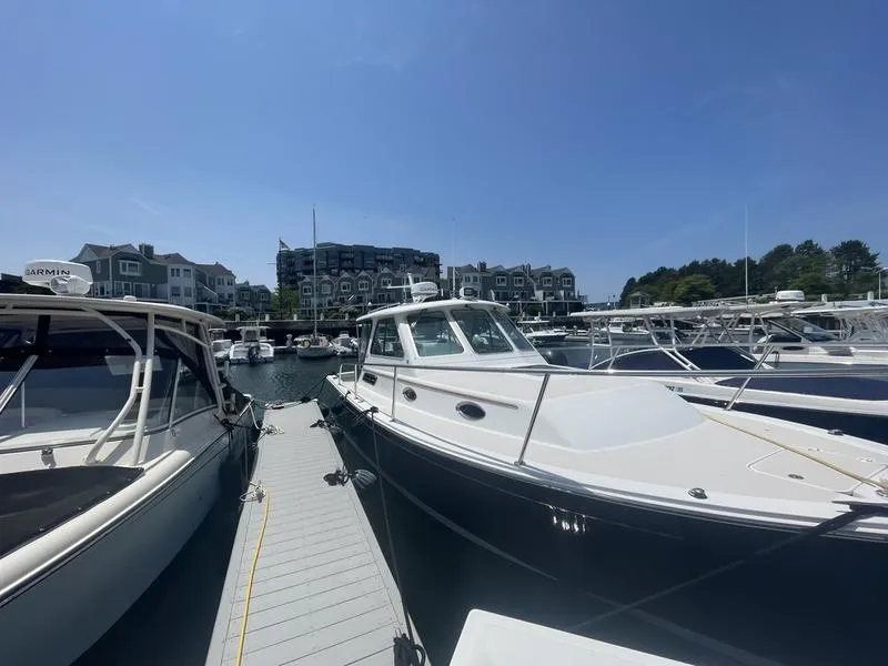 Slide: The Image of 2006 Back Cove 29 boat docked at a marina under clear blue skies. - 9