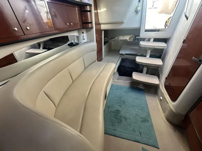 Slide: The Image of Interior of 2007 Sea Ray 300 Sundancer with beige seating and wooden cabinets. - 13