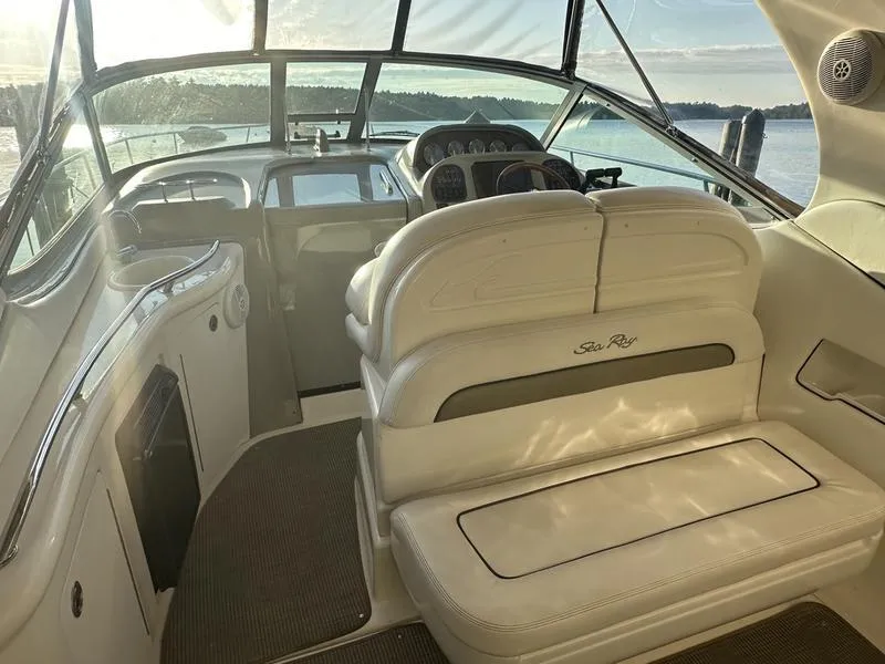 Slide: The Image of 2007 Sea Ray 300 Sundancer boat interior with helm and seating, overlooking serene waters. - 5