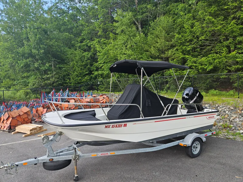 Slide: The Image of 2008 Boston Whaler 170 Montauk boat on trailer, parked outdoors with trees in background. - 13