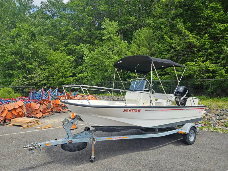 Slide: The Image of 2008 Boston Whaler 170 Montauk boat on trailer, parked near forested area. - 23