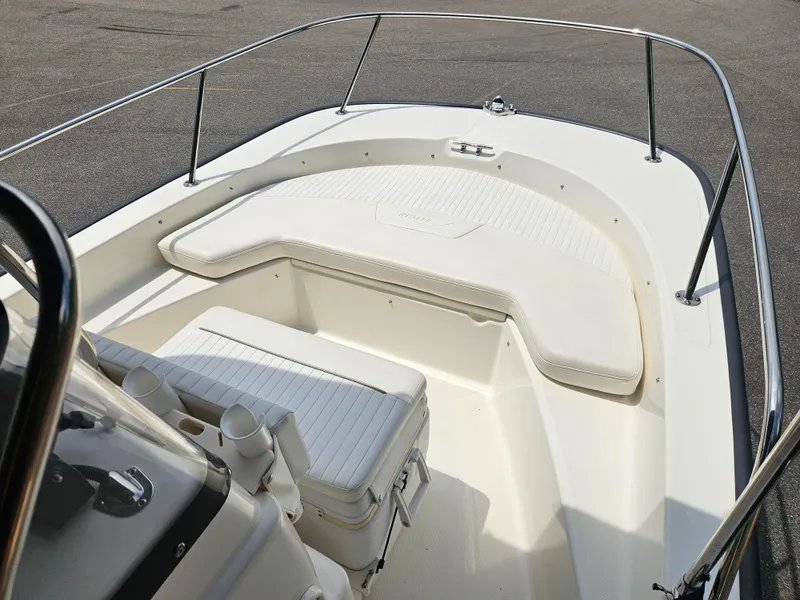 Slide: The Image of 2008 Boston Whaler 170 Montauk boat interior with cushioned seating and stainless steel railings. - 25