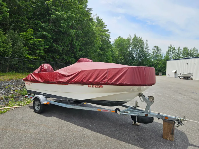 Slide: The Image of 2008 Boston Whaler 170 Montauk boat on trailer with red cover, parked outdoors. - 34