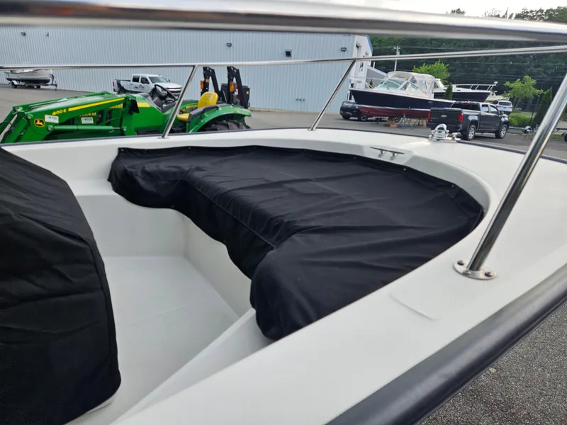Slide: The Image of 2008 Boston Whaler 170 Montauk boat with black cover, parked near green tractor. - 7