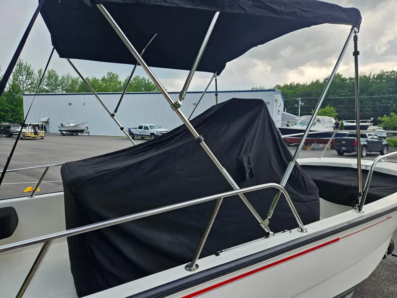 Slide: The Image of 2008 Boston Whaler 170 Montauk boat with cover and canopy in a parking lot. - 8