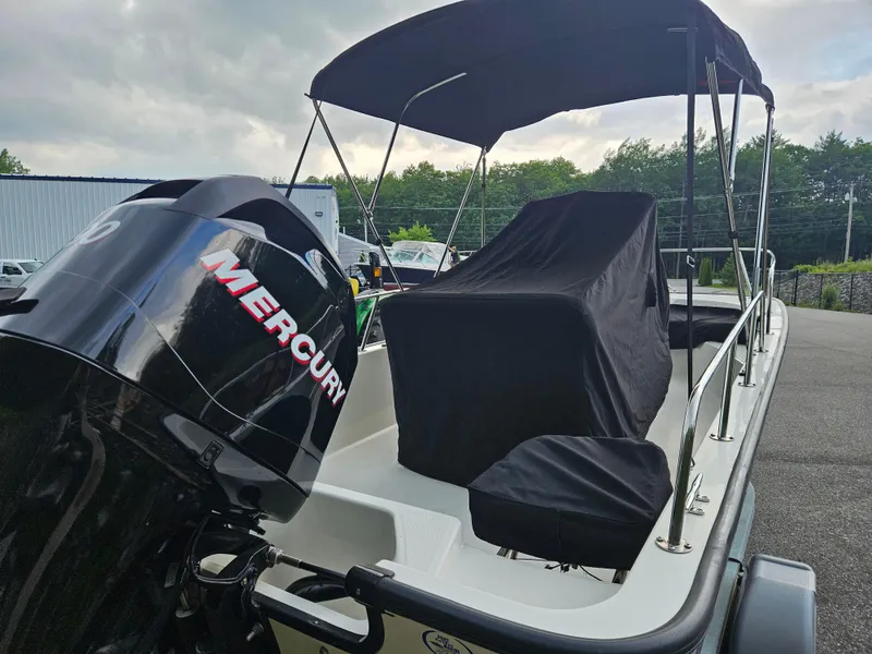 Slide: The Image of 2008 Boston Whaler 170 Montauk boat with Mercury engine, covered seats, and canopy. - 9
