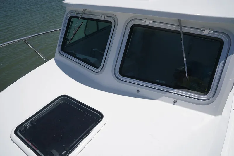 Slide: The Image of Manufacturer Provided Image: Parker 2120 Sport Cabin 2020 boat windows and deck hatch on water. - 2