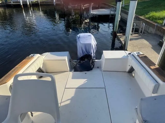 Slide: The Image of 1997 Sea Ray Laguna 21 boat docked by the water, featuring spacious seating and covered motor. - 3