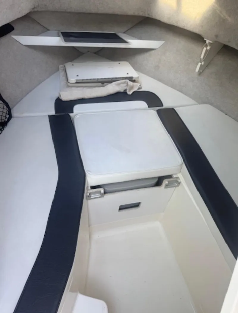 Slide: The Image of Interior of a 1997 Sea Ray Laguna 21 boat, featuring cushioned seating and storage. - 6