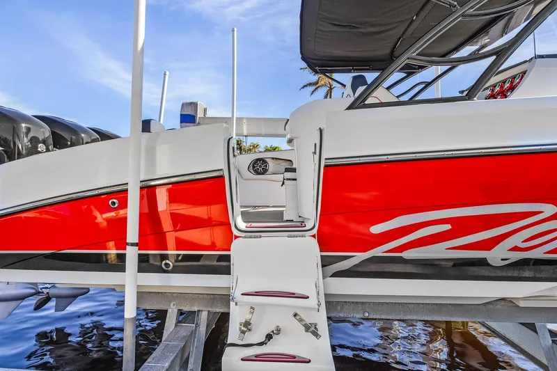 Slide: The Image of 2020 Renegade 33' Open boat with red and white exterior, docked on a lift. - 2