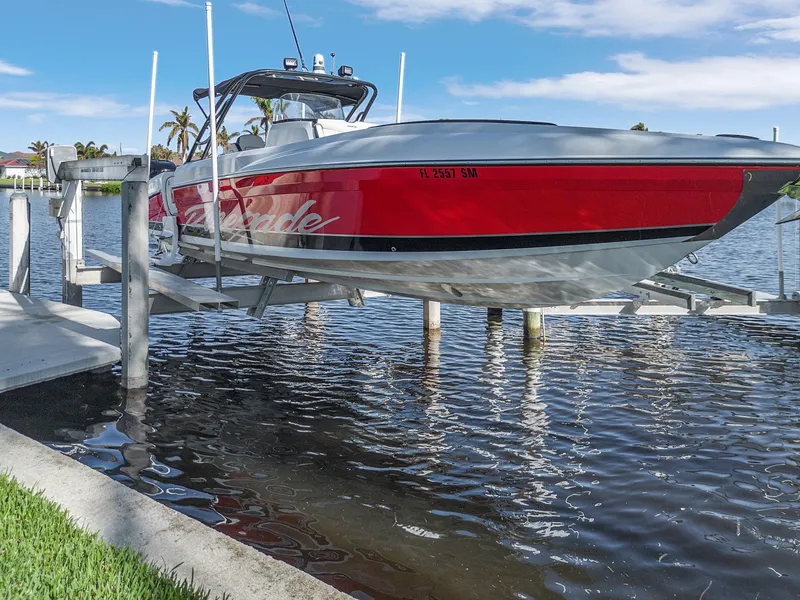 Slide: The Image of 2020 Renegade 33' Open boat on lift, red and white design, docked by waterfront. - 23
