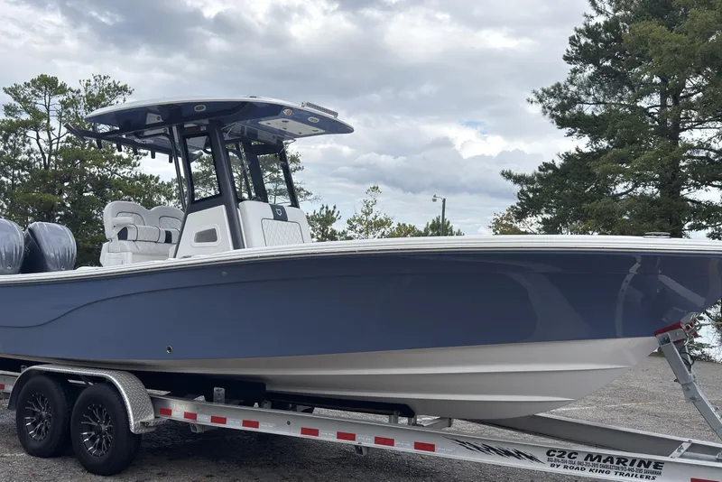 Slide: The Image of 2025 Sea Fox 282 Hybrid LT boat on trailer, parked outdoors under cloudy sky. - 2