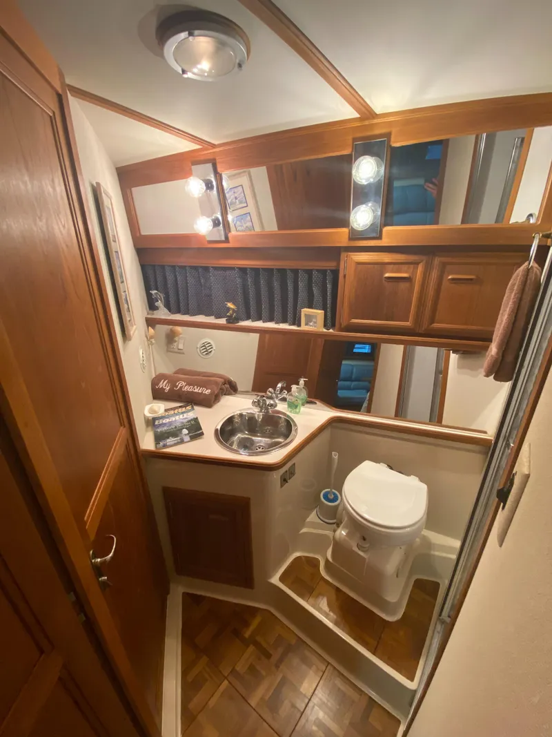 Slide: The Image of 1988 Carver 4207MY yacht bathroom with wood accents, sink, and toilet. - 10