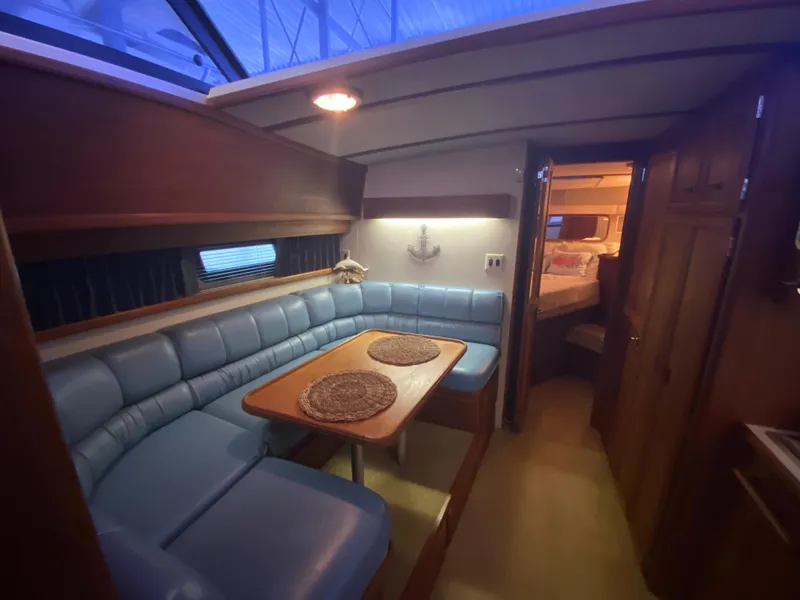 Slide: The Image of Interior of 1988 Carver 4207MY yacht with blue seating and wooden table. - 13