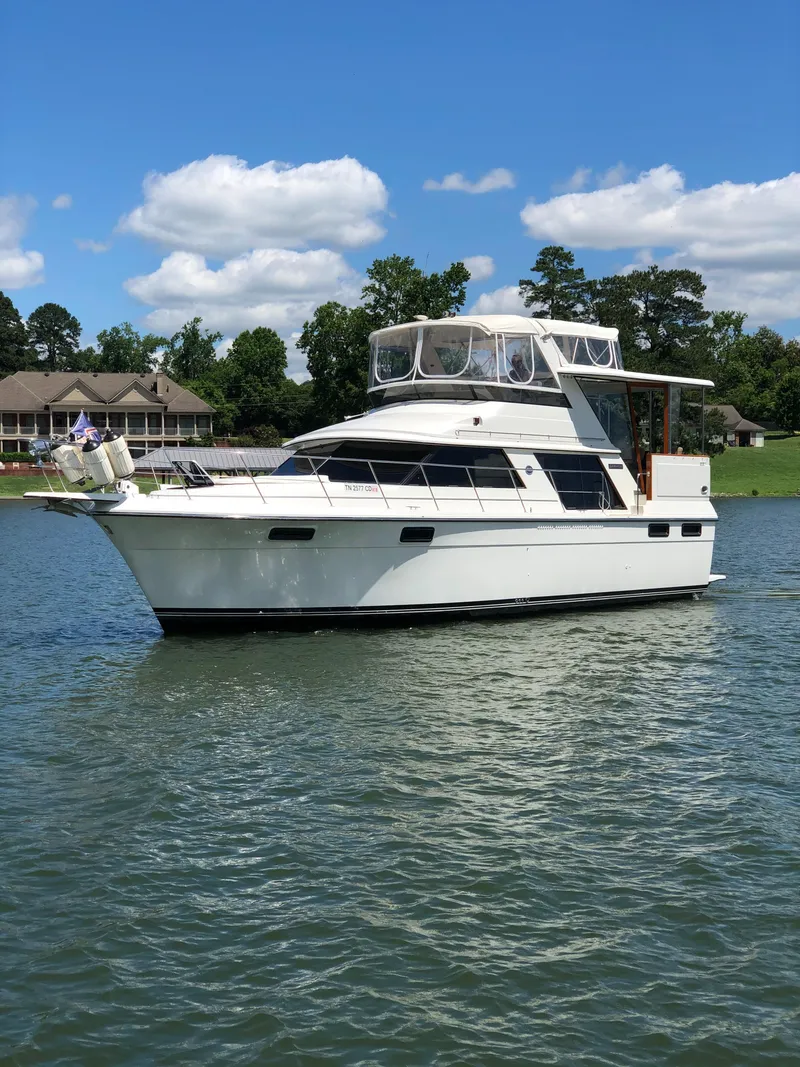 Slide: The Image of 1988 Carver 4207MY yacht on a serene lake with clear skies. - 2