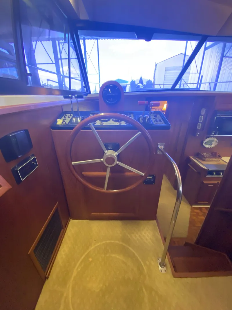 Slide: The Image of Interior helm of 1988 Carver 4207MY yacht with wooden steering wheel and control panel. - 14