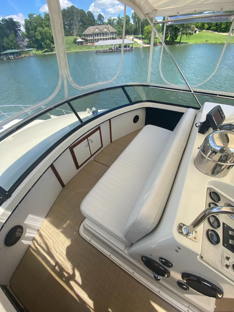 Slide: The Image of 1988 Carver 4207MY yacht interior with lake view, featuring helm and seating area. - 7