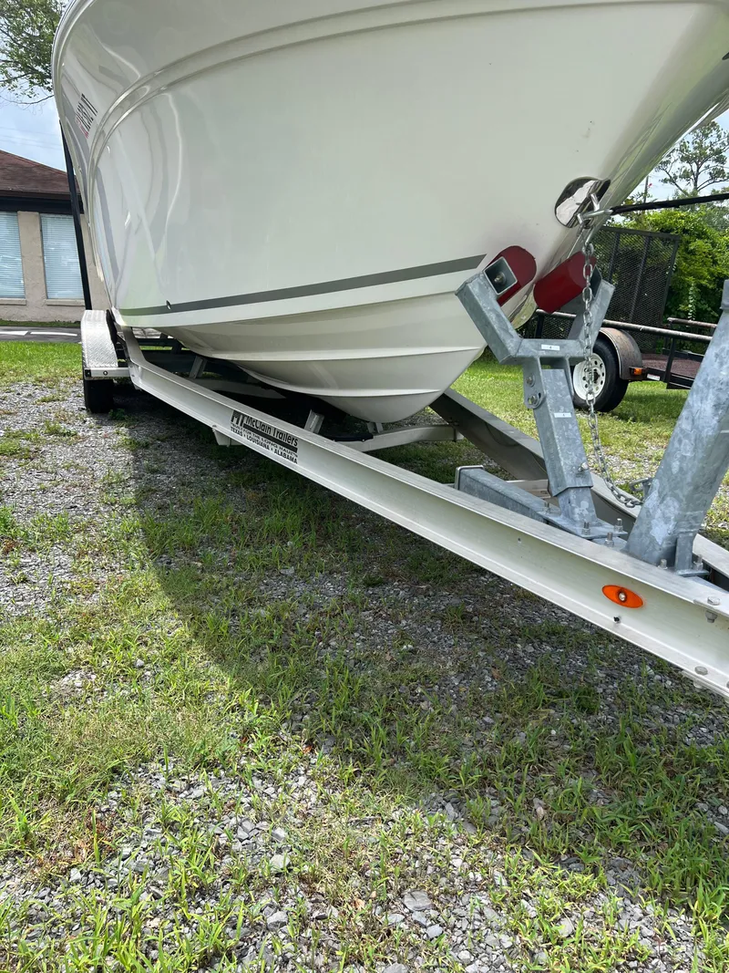 Slide: The Image of 2022 Sea Fox 248 Commander boat with T-top, viewed from the front, against a tree backdrop. - 20