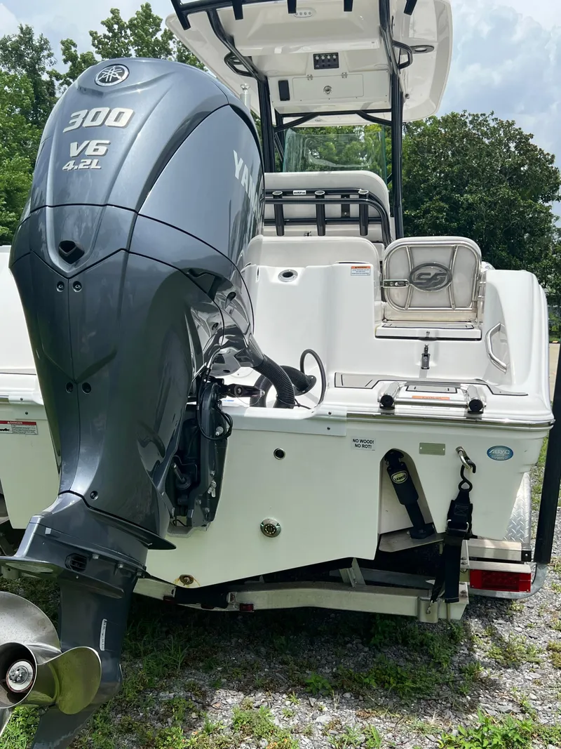 Slide: The Image of 2022 Sea Fox 248 Commander boat interior with console and seating, set against a lush green backdrop. - 8