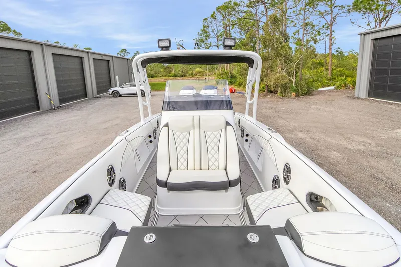 Slide: The Image of 2020 Renegade 32' Cuddy boat with white seating, parked near storage units. - 18