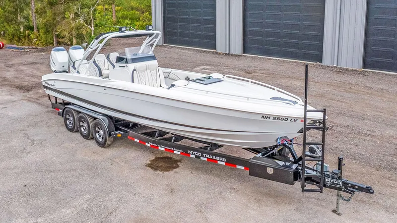 Slide: The Image of 2020 Renegade 32' Cuddy boat on trailer, parked outdoors. - 22