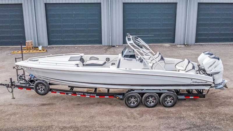 Slide: The Image of 2020 Renegade 32' Cuddy boat on trailer, parked outside garage. - 23