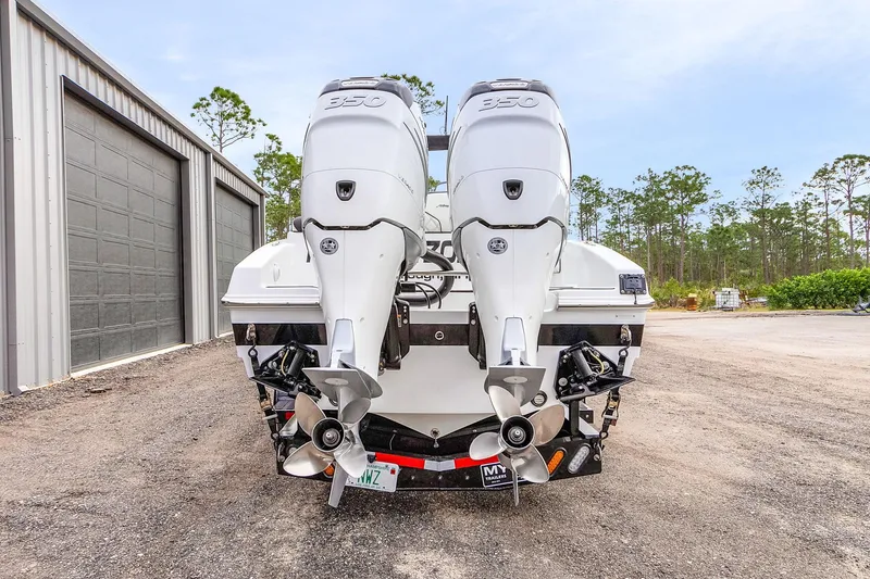 Slide: The Image of 2020 Renegade 32' Cuddy boat with dual outboard engines, parked outdoors. - 3