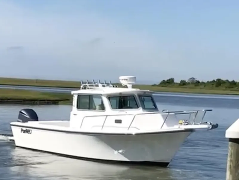 Slide: The Image of 2021 Parker 2520 XLD Sport Cabin boat cruising on a calm waterway. - 0