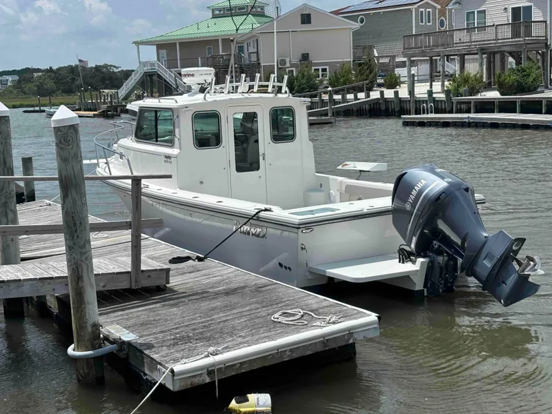 Slide: The Image of 2021 Parker 2520 XLD Sport Cabin boat docked with Yamaha outboard motor. - 1