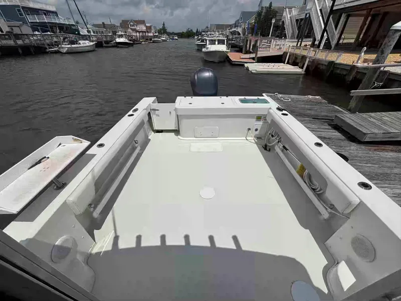 Slide: The Image of 2021 Parker 2520 XLD Sport Cabin boat docked in a marina, showcasing spacious deck area. - 16