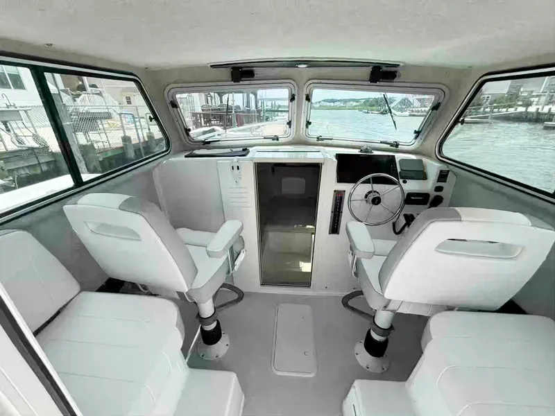 Slide: The Image of Interior of a 2021 Parker 2520 XLD Sport Cabin boat with seating and steering wheel. - 9