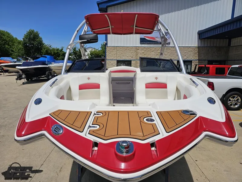 Slide: The Image of 2008 Chaparral Sunesta 224 boat with red and white interior, docked outdoors. - 11