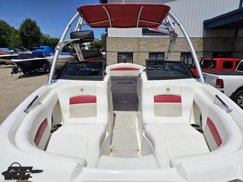 Slide: The Image of 2008 Chaparral Sunesta 224 boat with red and white interior, docked outdoors. - 12