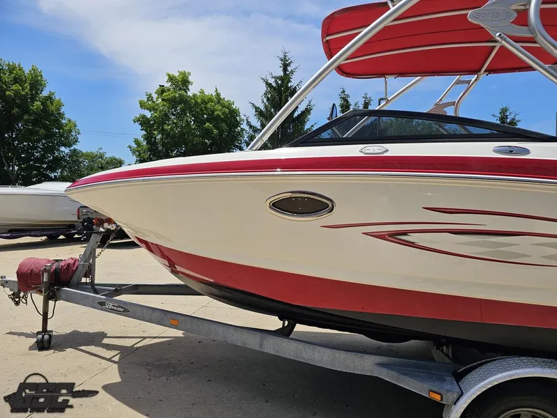 Slide: The Image of 2008 Chaparral Sunesta 224 boat on trailer, featuring red and white design under a clear sky. - 19