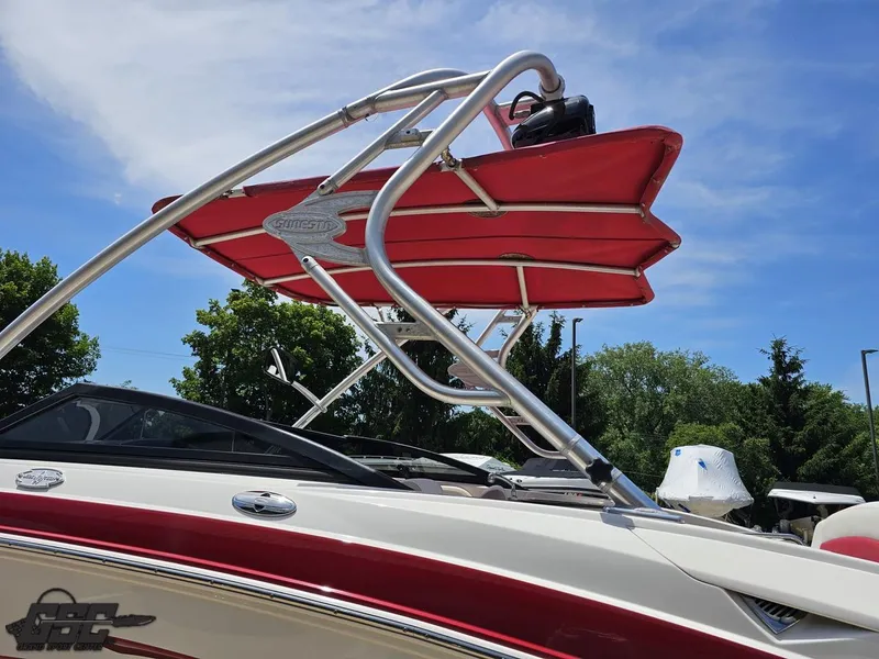 Slide: The Image of 2008 Chaparral Sunesta 224 boat with red canopy and sleek design against blue sky. - 23