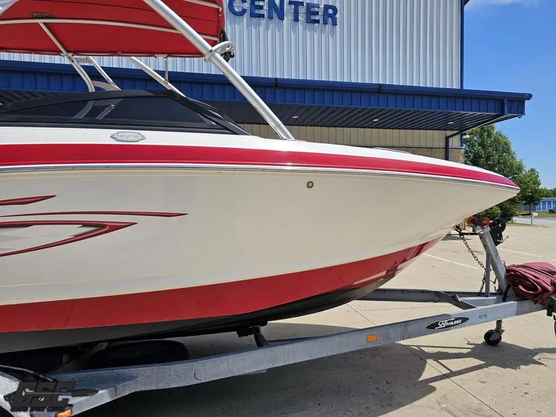 Slide: The Image of 2008 Chaparral Sunesta 224 boat on trailer, red and white design, parked outside a building. - 4