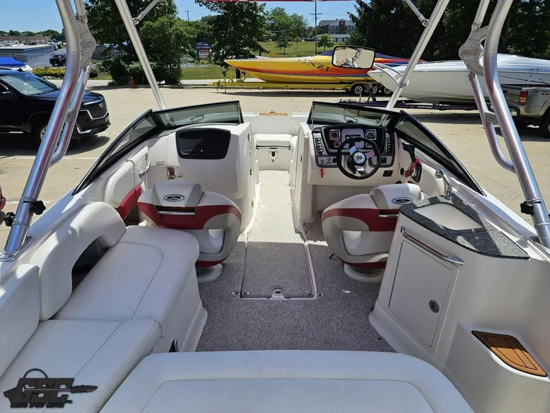Slide: The Image of 2008 Chaparral Sunesta 224 boat interior with white and red seating, steering wheel, and dashboard. - 44