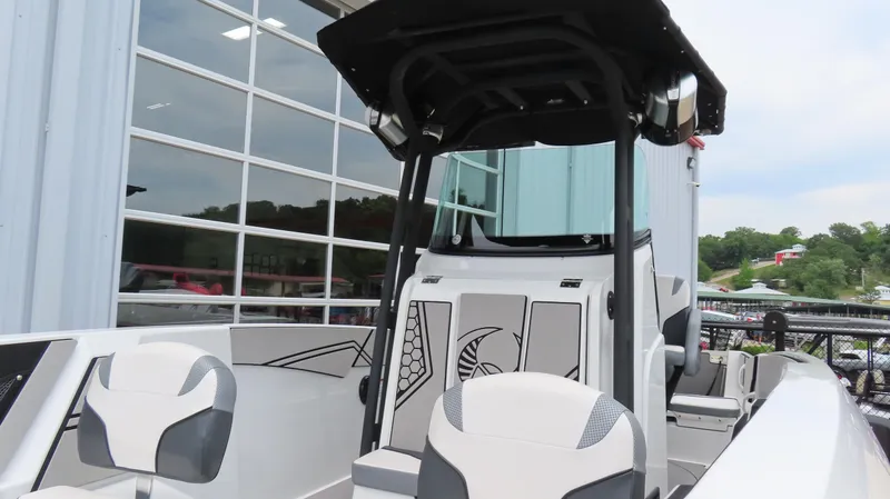 Slide: The Image of 2020 Scarab 255 Open G boat with modern seating and sleek design near a glass building. - 19