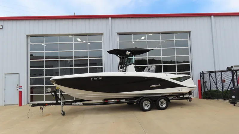 Slide: The Image of 2020 Scarab 255 Open G boat on trailer outside a garage. - 3