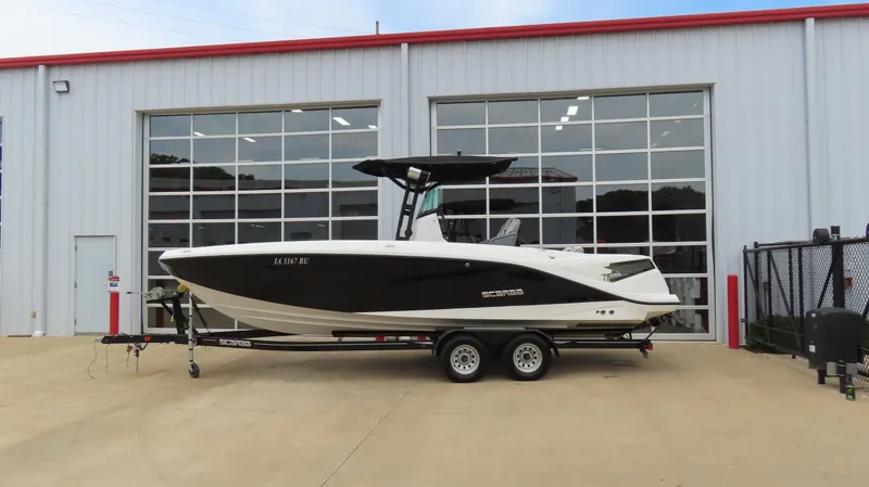 Slide: The Image of 2020 Scarab 255 Open G boat on trailer outside a garage. - 5