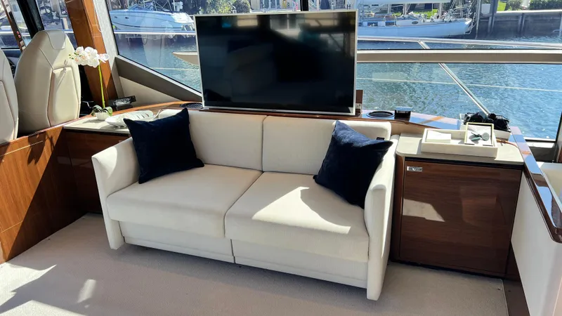 Slide: The Image of Luxurious 2019 Princess F62 yacht interior with sofa, TV, and waterfront view. - 15