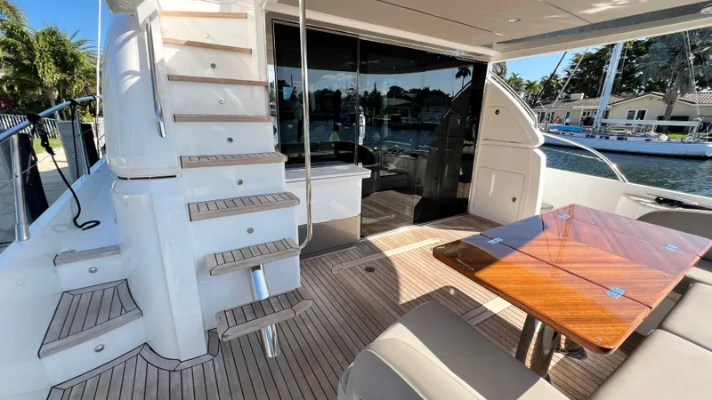 Slide: The Image of Luxurious 2019 Princess F62 yacht interior with wooden table and staircase, docked by the water. - 36