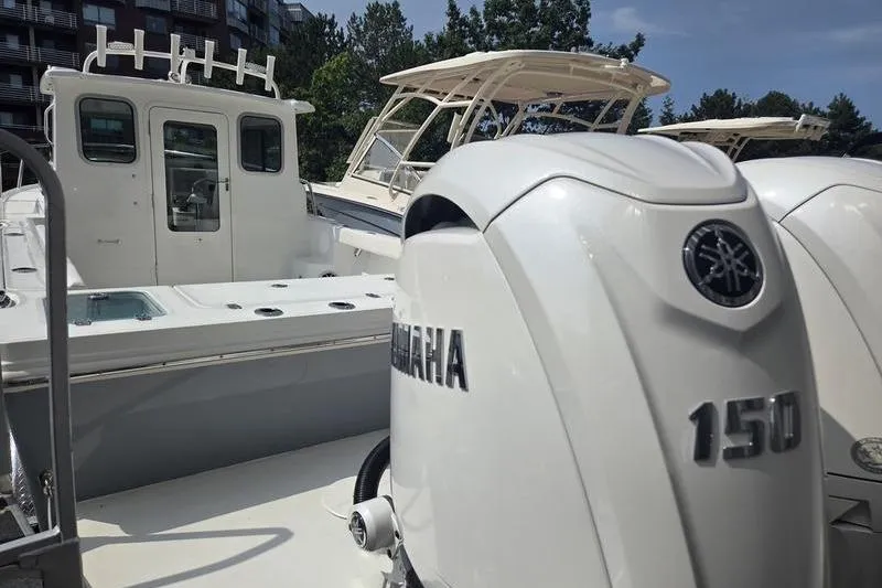 Slide: The Image of 2026 Parker 2421 EXPLORER boat with Yamaha 150 outboard engines, docked under clear skies. - 4