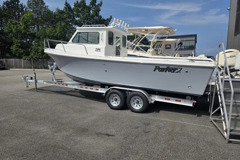 Slide: The Image of 2026 Parker 2421 EXPLORER boat on trailer, parked outdoors under clear sky. - 6