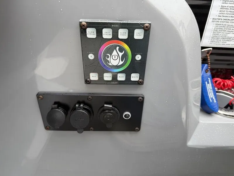 Slide: The Image of Control panel on a 2021 Godfrey Monaco 235 SFL GTP boat, featuring lighting and power outlets. - 21