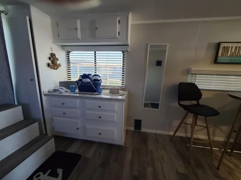 Slide: The Image of 1977 Stardust Cruisers houseboat interior with cozy bedroom, bathroom, and dining area. - 13