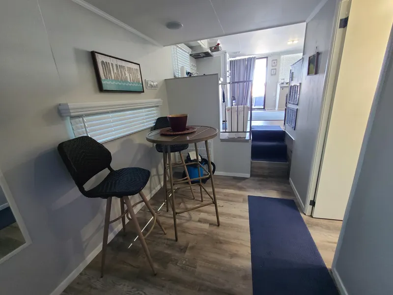 Slide: The Image of 1977 Stardust Cruisers houseboat bedroom with striped bedding, window blinds, and wooden flooring. - 14