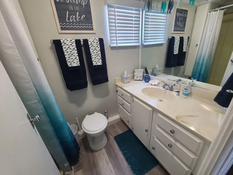 Slide: The Image of 1977 Stardust Cruisers houseboat interior with modern decor, white cabinets, and nautical accents. - 15